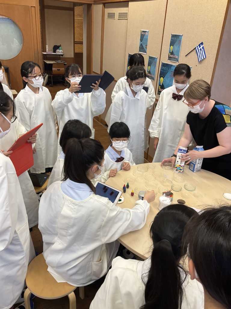 teacher showing students how to perform the experiment